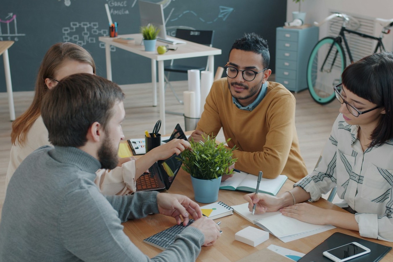 Team bespricht sich am Tisch im Büro